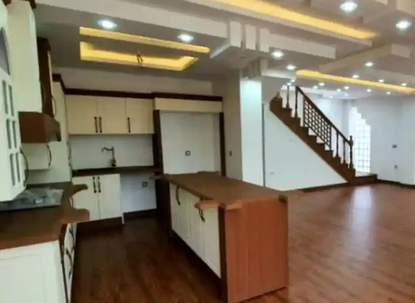 کابینت و کشوهای نمای چوبی ونورپردازی با نور زرد آشپزخانه ویلا در زرگر