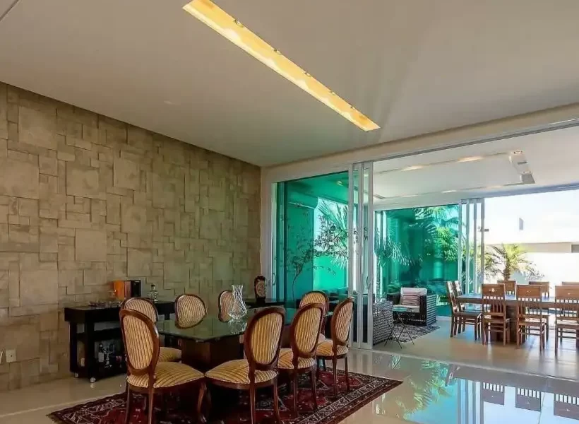 میز غذاخوری در سالن نشیمن و سالن پذیرایی با پنجره سبز ویلا در بابل