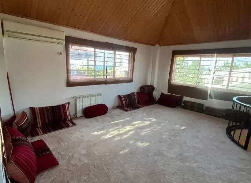 فرشکرمی رنگ با پشتی های قرمز شاه نشین ویلا در باقر تنگه