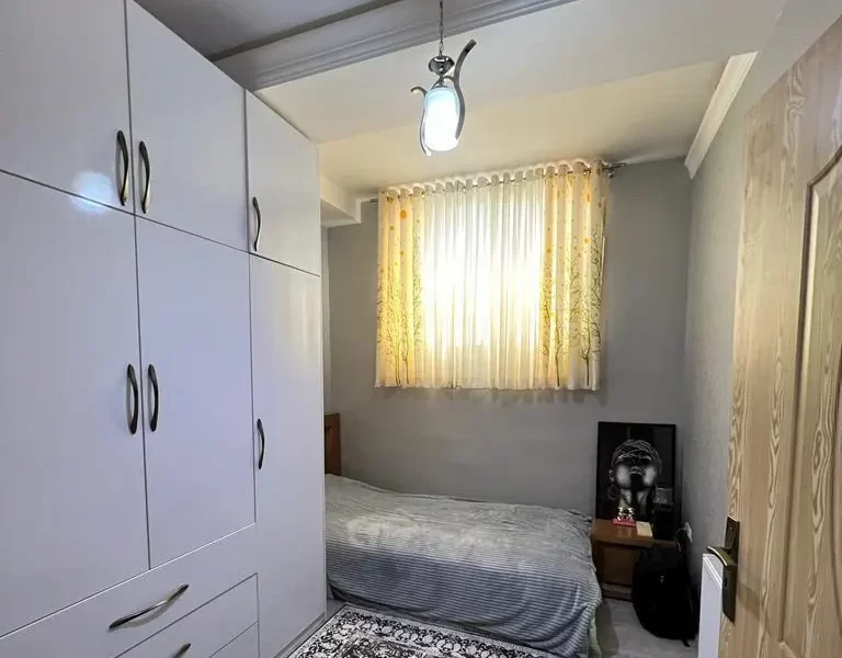 کمد دیواری و تخت خواب با روتختی طوسی رنگ اتاق خواب آپارتمان در زرگر