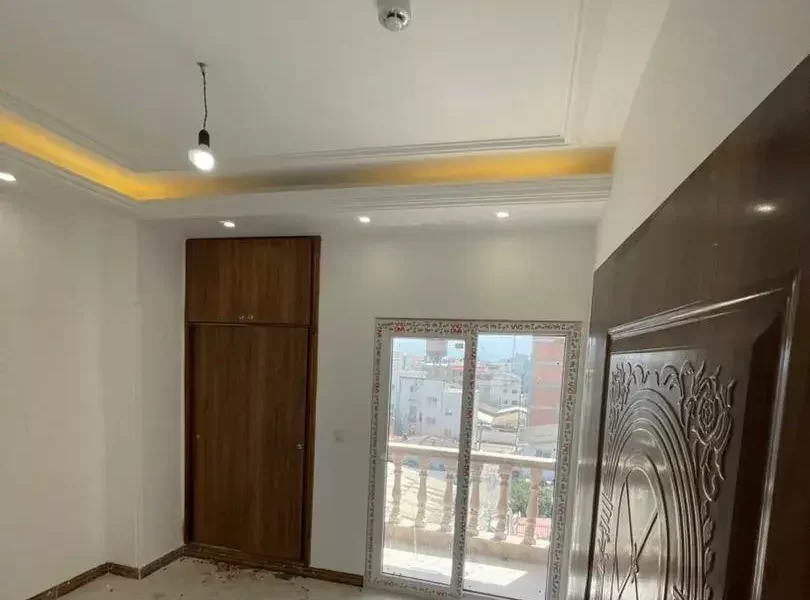 پنجره رو به تراس و سقف نورپردازی شده با نور زرد اتاق خواب آپارتمان در بهنمیر