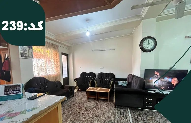 مبلمان قهوه ای رنگ و تلویزیون و فرش های کرمی رنگ سالن نشیمن آپارتمان در باقرتنگه