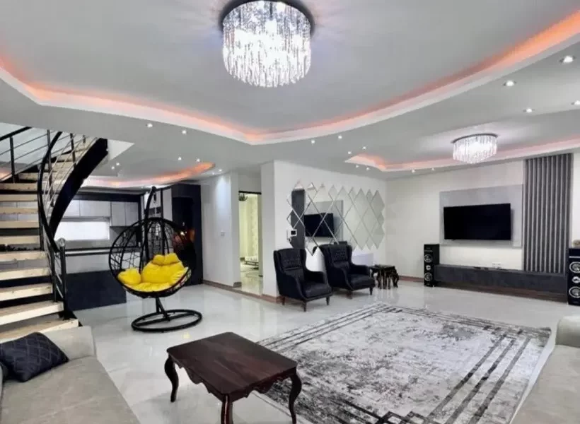 مبلمان مشکی و سقف نور پردازی شده با نور نارنجی سالن نشیمن ویلا در بابلسر