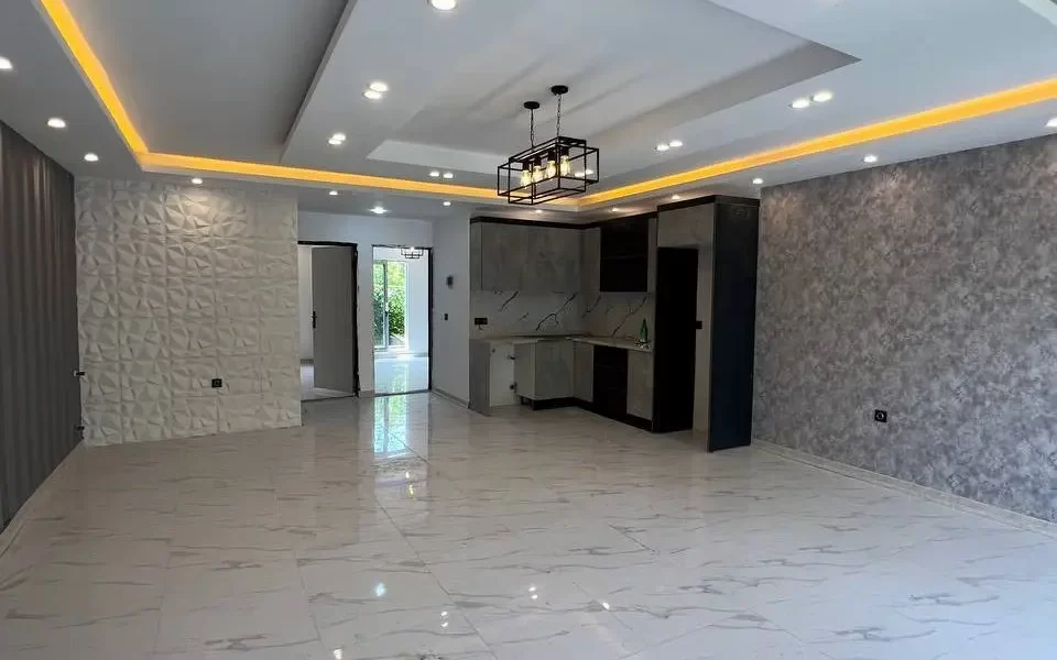 سرامیک سفید و سقف نورپردازی شده با نور زرد سالن نشیمن ویلا در شیرگاه