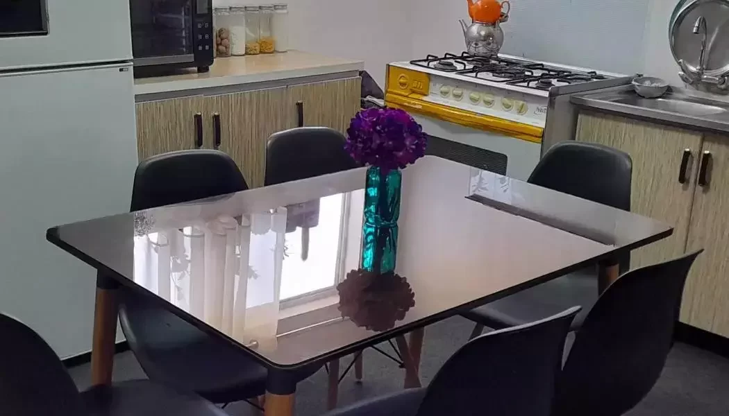 میز غذاخوری و کابینت های قهوه ای رنگ و یخچال آشپزخانه آپارتمان در پل سفید