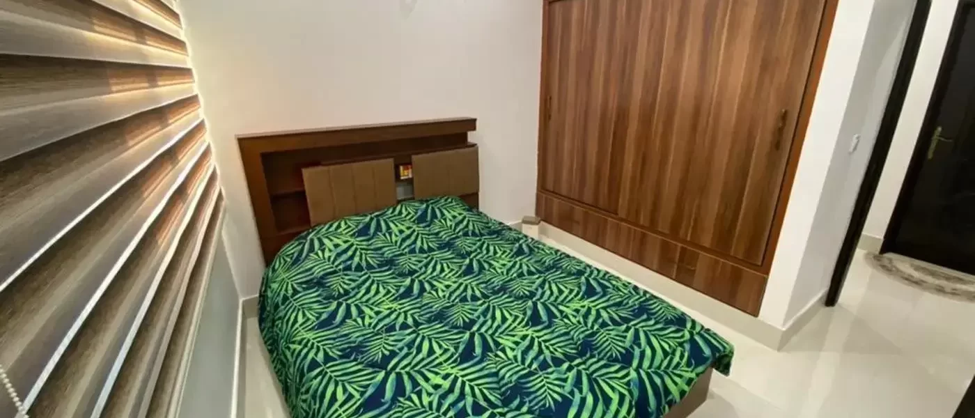 تخت خواب با روتختی سبز و کمد دیواری اتاق خواب آپارتمان در قائم شهر