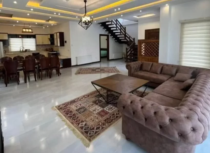 مبلمان قهوه ای رنگ و سقف نور پردازی شده با نور زرد سابلن نشیمن ویلا در سوادکوه