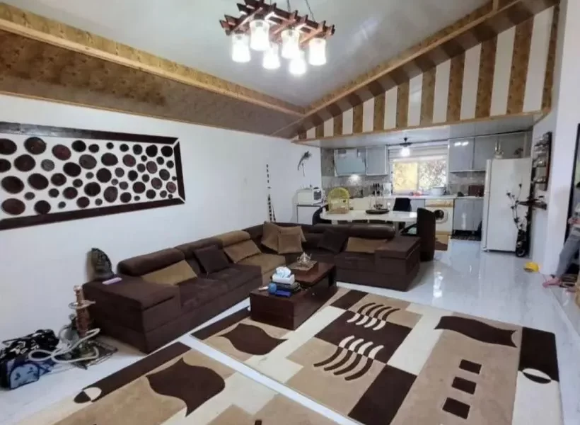 کابینت های سفید رنگ و یخچال آشپزخانه و مبلمان قهوه ای رنگ سالن نشیمن ویلا در شیرگاه