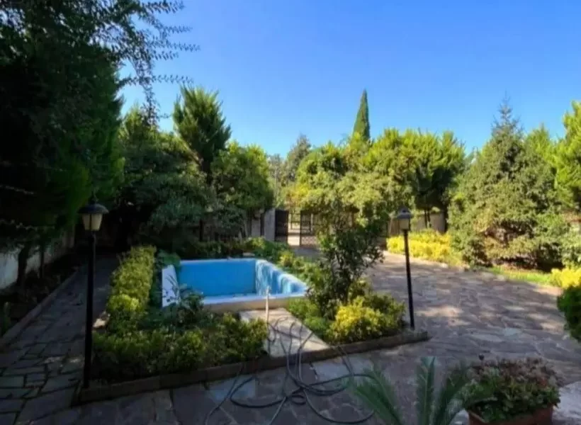 محوطه سنگفرش شده با باغچه ی سرسبز و استخر در محوطه ویلا در سوادکوه