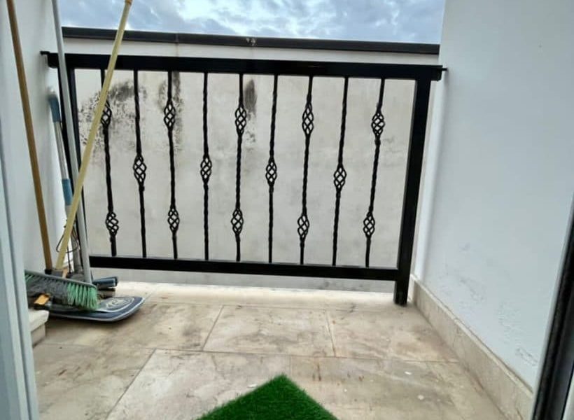 تراس با نرده های فرفوژه مشکی و کفپوش چمن مصنوعی آپارتمان در پل سفید 98595