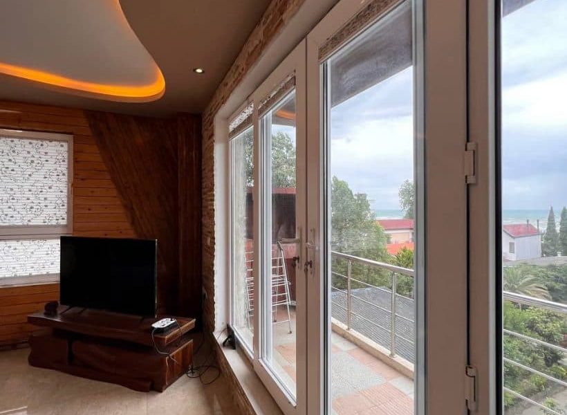 پنجره دوجداره رو به تراس و میزتلوزیونی چوبی آپارتمان در زیرآب 8989