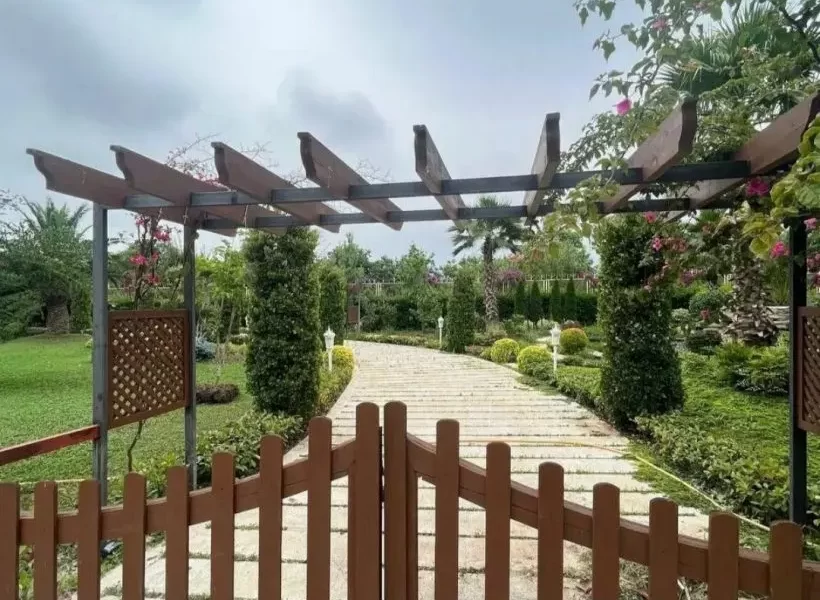 ورودی با درب نرده ای چوبی و گل های بنفش ویلا در بابلسر 94616