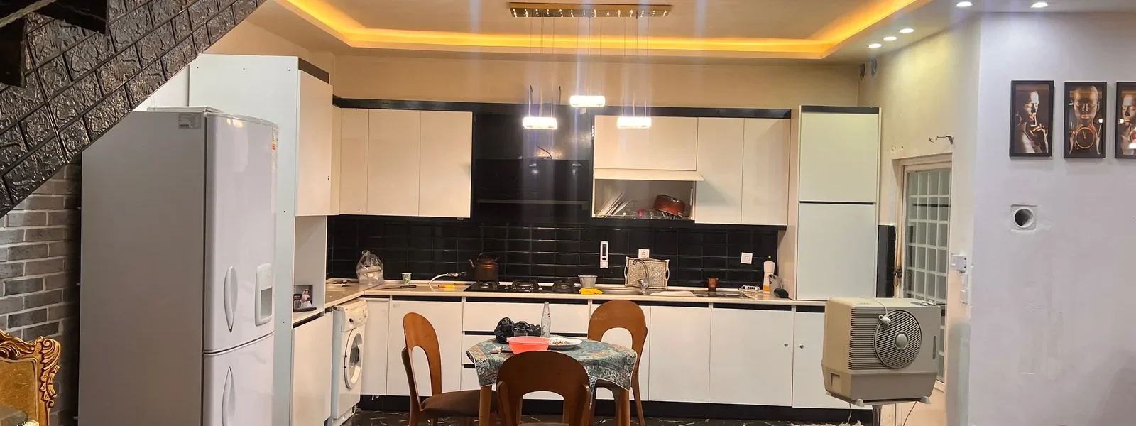 آشپزخانه با یخچال، کابینت های سفید و میز ناهارخوری، لباسشویی و کفپوش سرامیکی ویلا در سوادکوه 586445