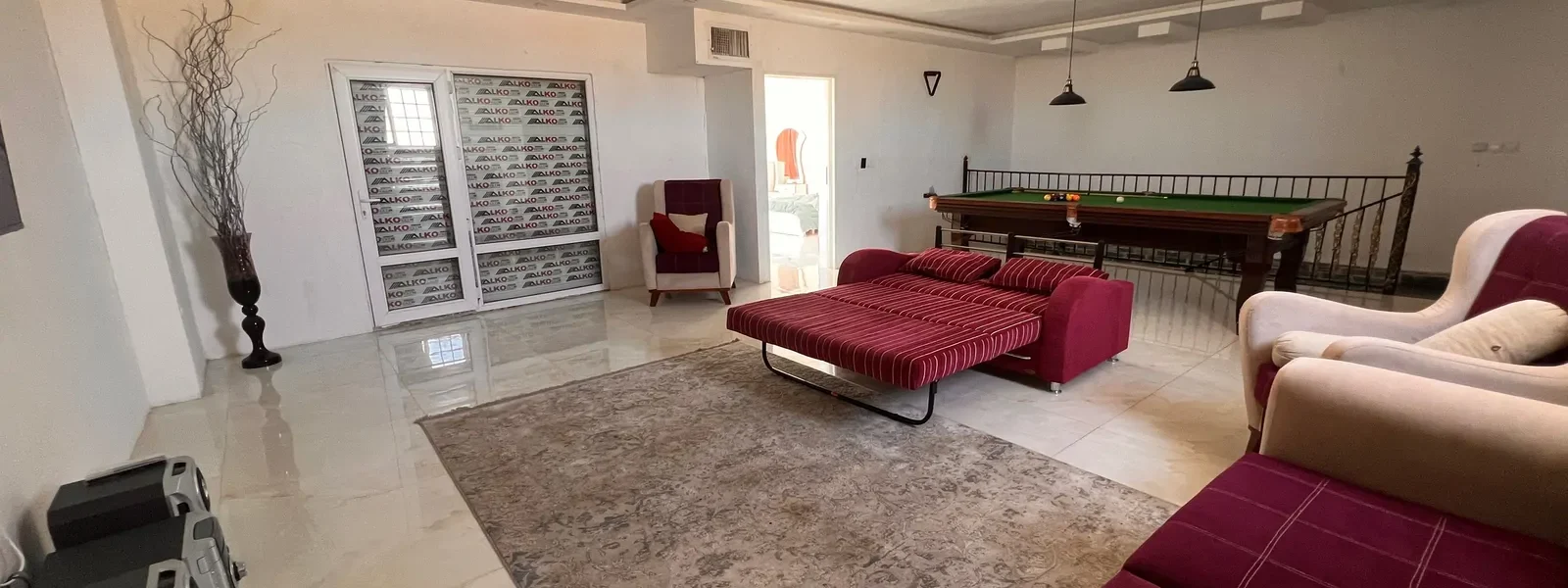 سالن گیم با میز و بیلیارد و مبلمان قرمز ویلا در سوادکوه 52694565