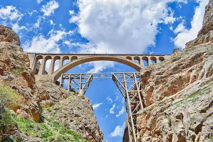 پل تاریخی و عظیم ورسک در دل صحره های بزرگ و زیر آسمان ابری در نزدیکی غار اسپهبد 4156415