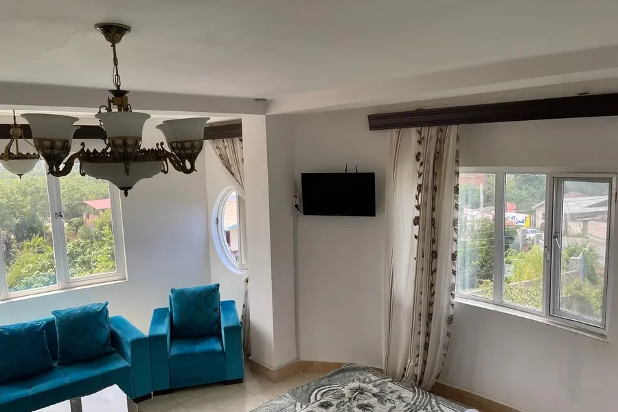 اتاق پذیرایی به همراه مبلمان آبی و پنجره های واحد آپارتمان در بابلسر 465938746975