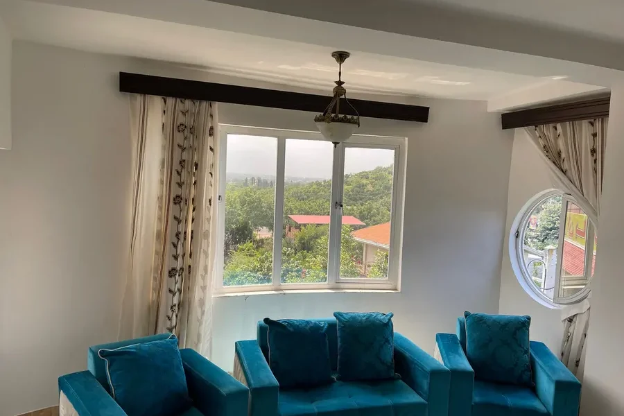 اتاق پذیرایی به همراه مبلمان آبی و پنجره های واحد آپارتمان در بابلسر 4659438746975