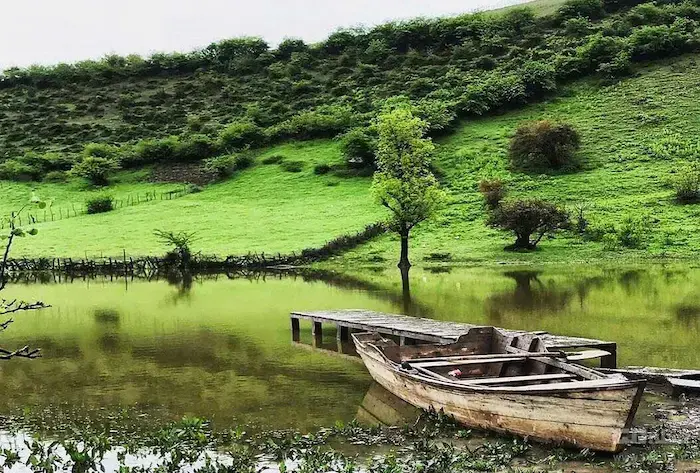 قایق به گل نشسته در کنار آب بندان و دشت سرسبز پارک جنگلی تلار، یکی از جاهای دیدنی قائمشهر 4785684735684